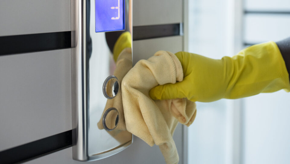 hand-cleaning-elevator-buttons-with-cloth